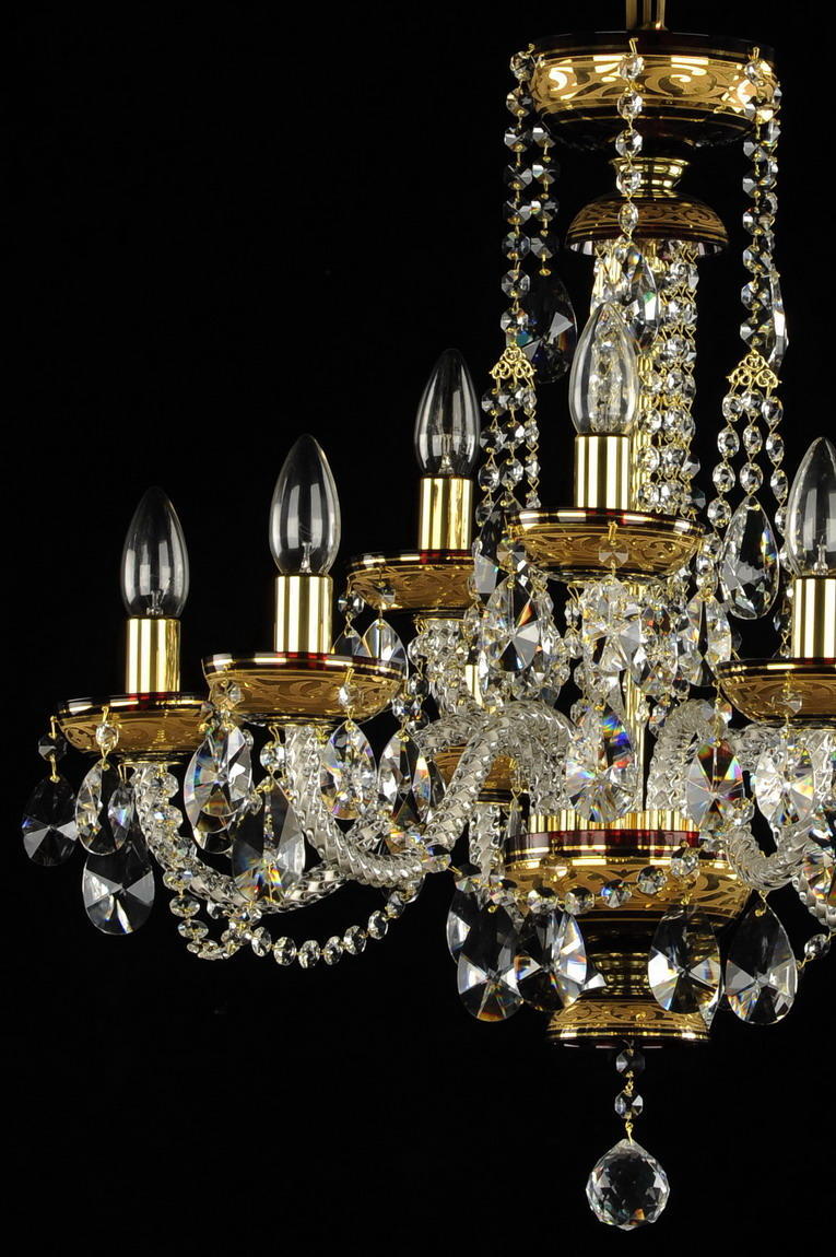 Vue rapprochée du lustre montrant bras dorés, bobèches et pendeloques de cristal
