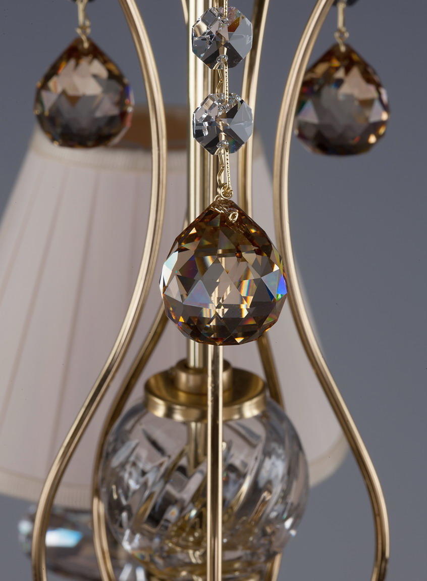 Détail macro d'une pampille ambrée, entretoises octogonales et sphère centrale de cristal
