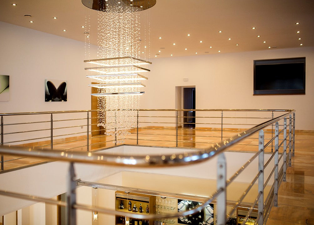 Vue depuis la mezzanine, le luminaire cascade éclaire la cage d'escalier et le garde-corps.