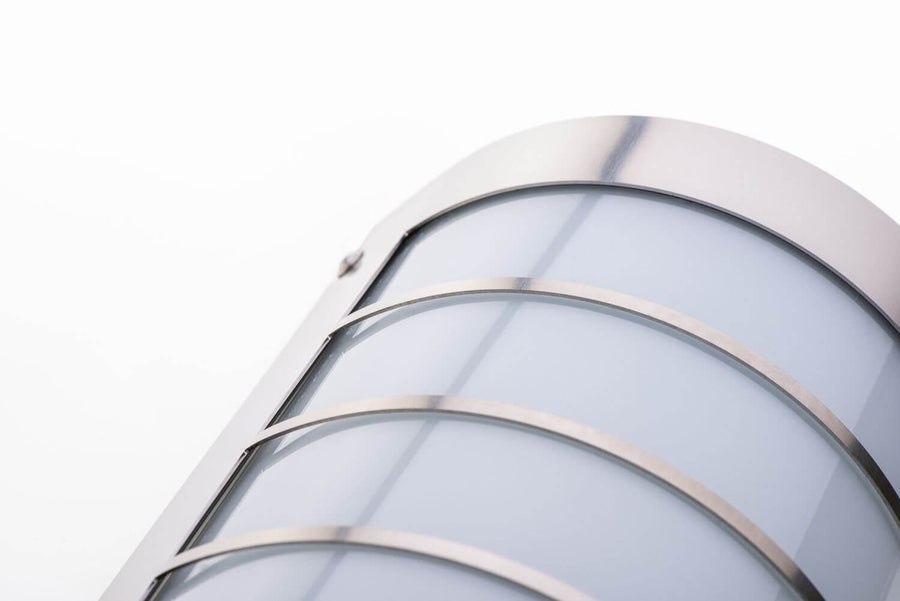 Détail en gros plan des bandes en inox brossé et du verre satiné, vue inclinée.