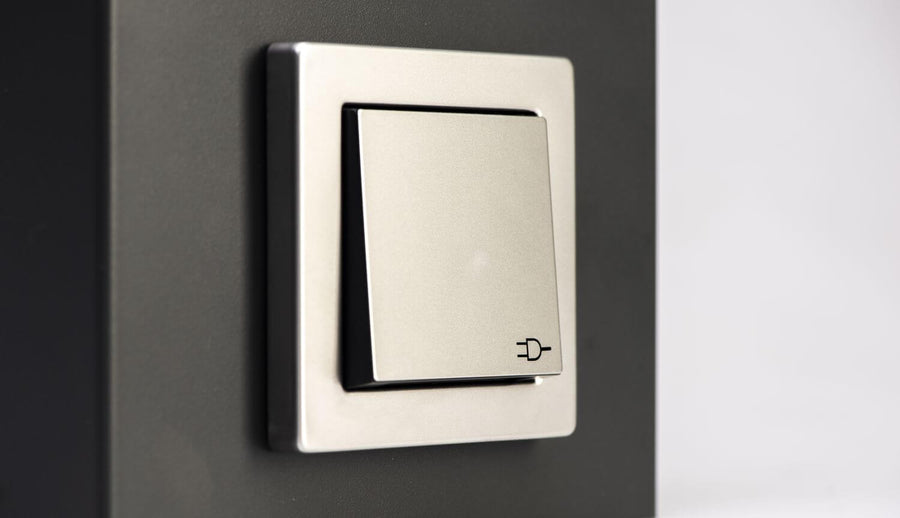 Gros plan sur l'interrupteur gris intégré au luminaire extérieur anthracite.