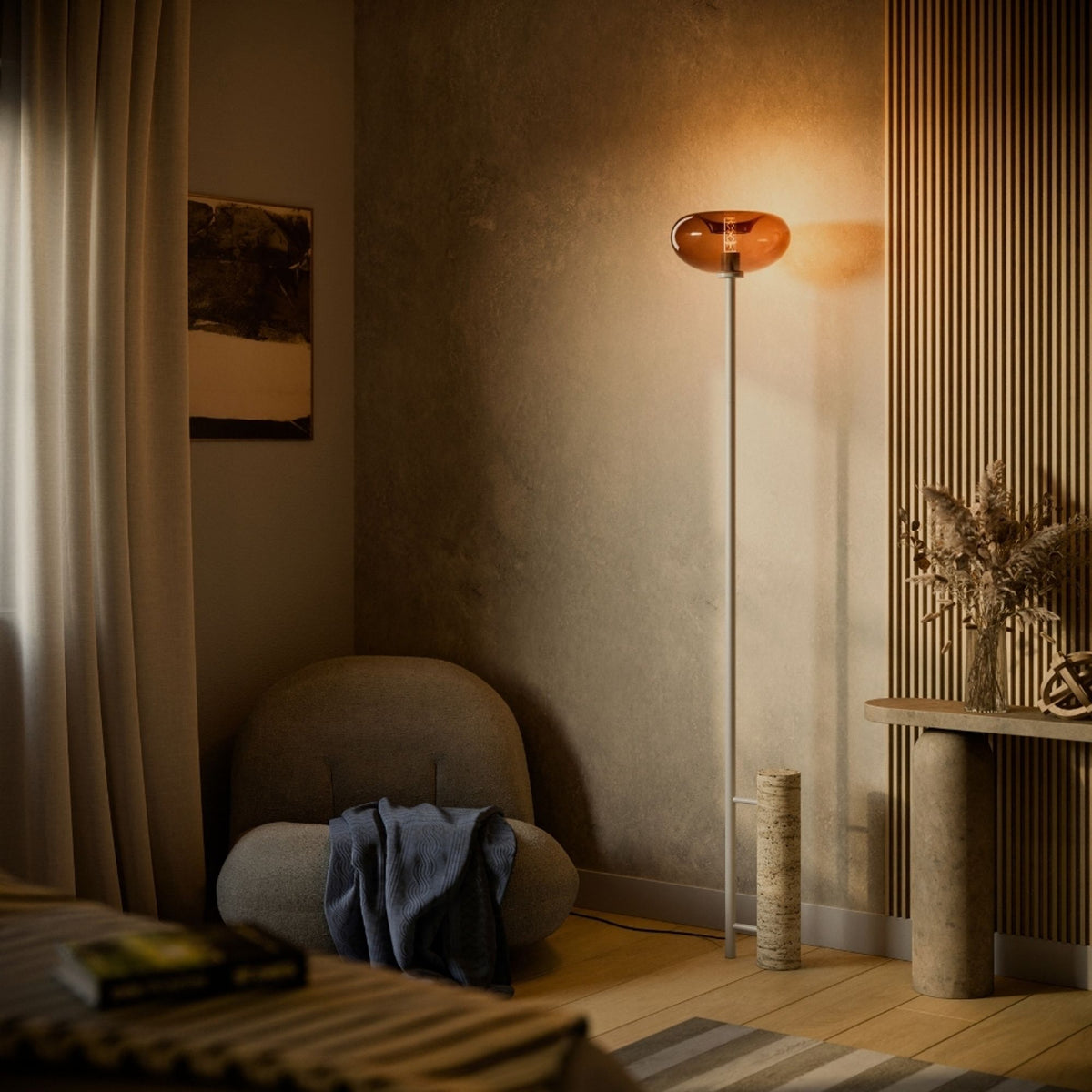 Mise en ambiance sombre d'un lampadaire à diffuseur ovale ambré contre un mur texturé