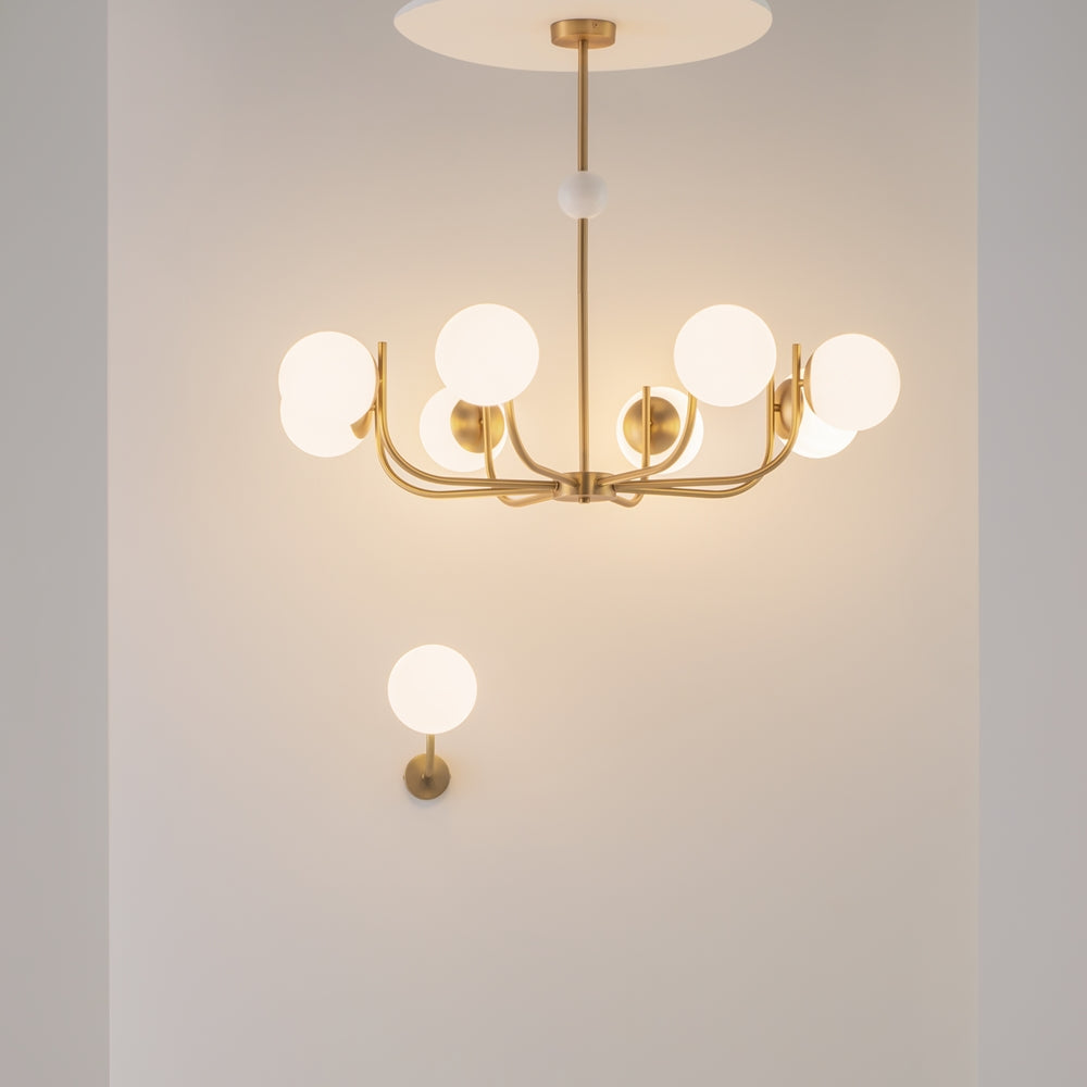 Mise en ambiance : lustre doré et applique murale dans une pièce claire