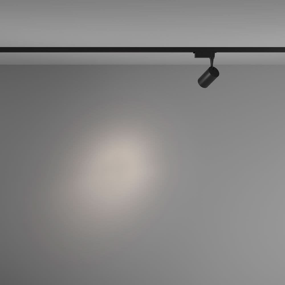 Mise en ambiance montrant le spot noir projetant un halo lumineux sur un mur gris.
