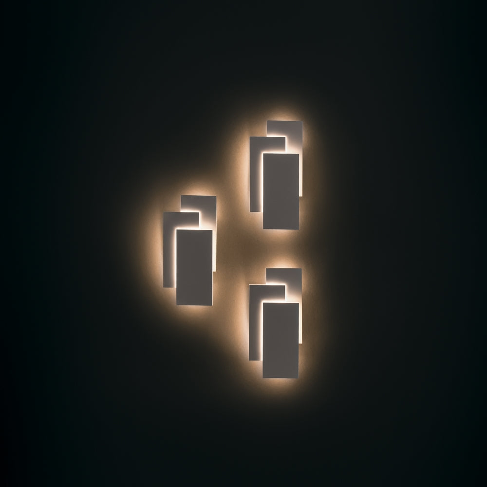 Mise en ambiance nocturne avec trois appliques allumées sur fond noir profond