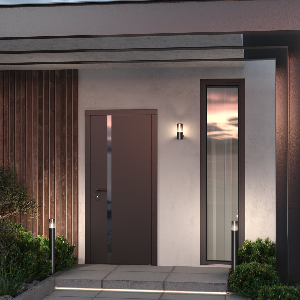 Mise en ambiance : applique allumée près d'une porte d'entrée moderne.