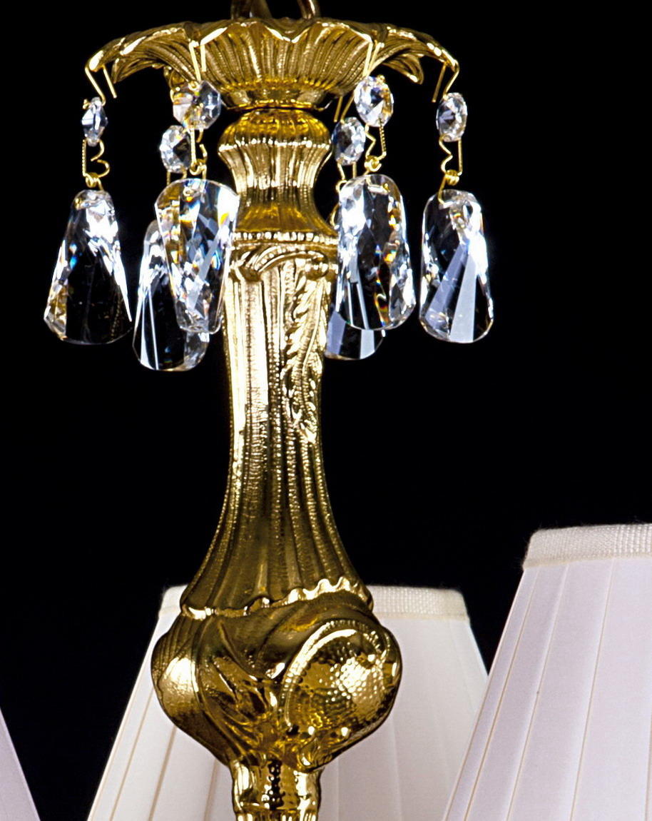 Gros plan du sommet mouluré doré et des pendentifs cristal sous la fixation