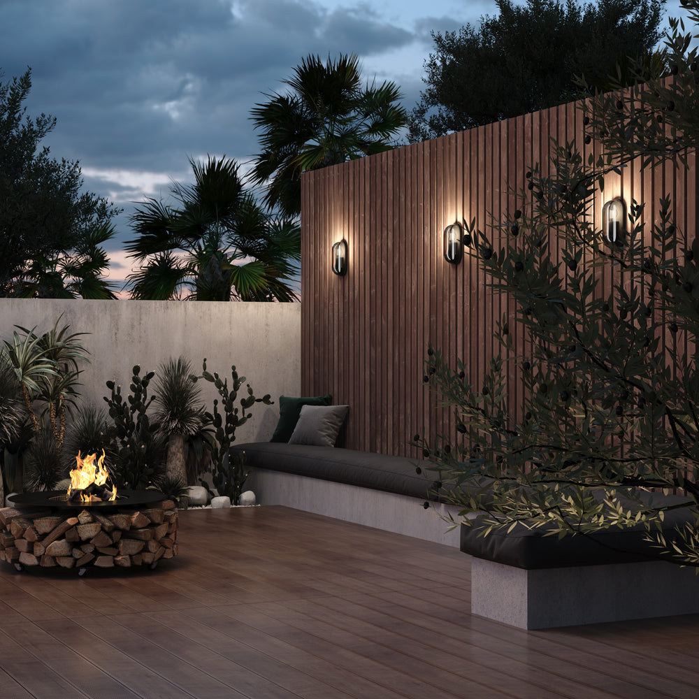 Mise en ambiance nocturne sur terrasse, trois appliques éclairant une paroi en bois