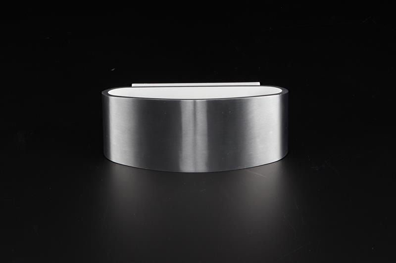 Vue de profil sur fond noir, corps cylindrique argenté et diffuseur blanc affleurant