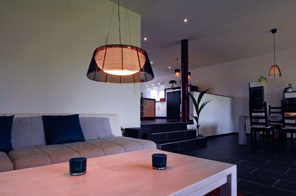 Mise en ambiance au-dessus d’un salon, suspension allumée dans un intérieur moderne.