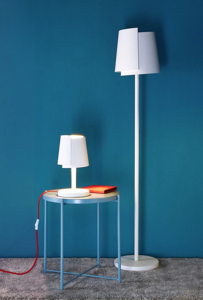 Mise en ambiance avec lampe de table et lampadaire assortis sur fond bleu.