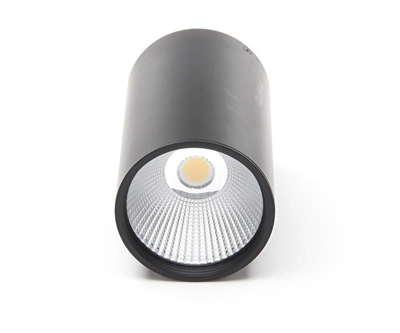 Vue frontale du spot noir éteint, lentille transparente et module LED central visibles.