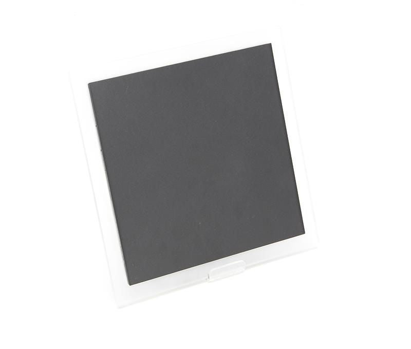 Vue inclinée du boîtier carré gris posé sur un support transparent.