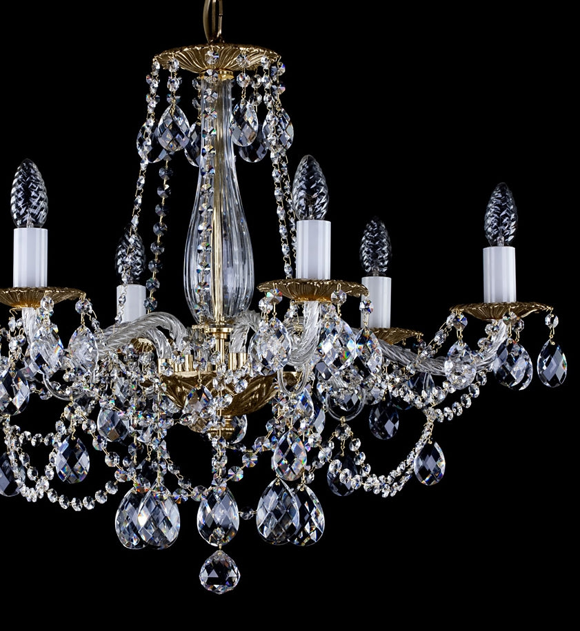 Vue rapprochée du lustre montrant bras dorés et pendeloques de cristal