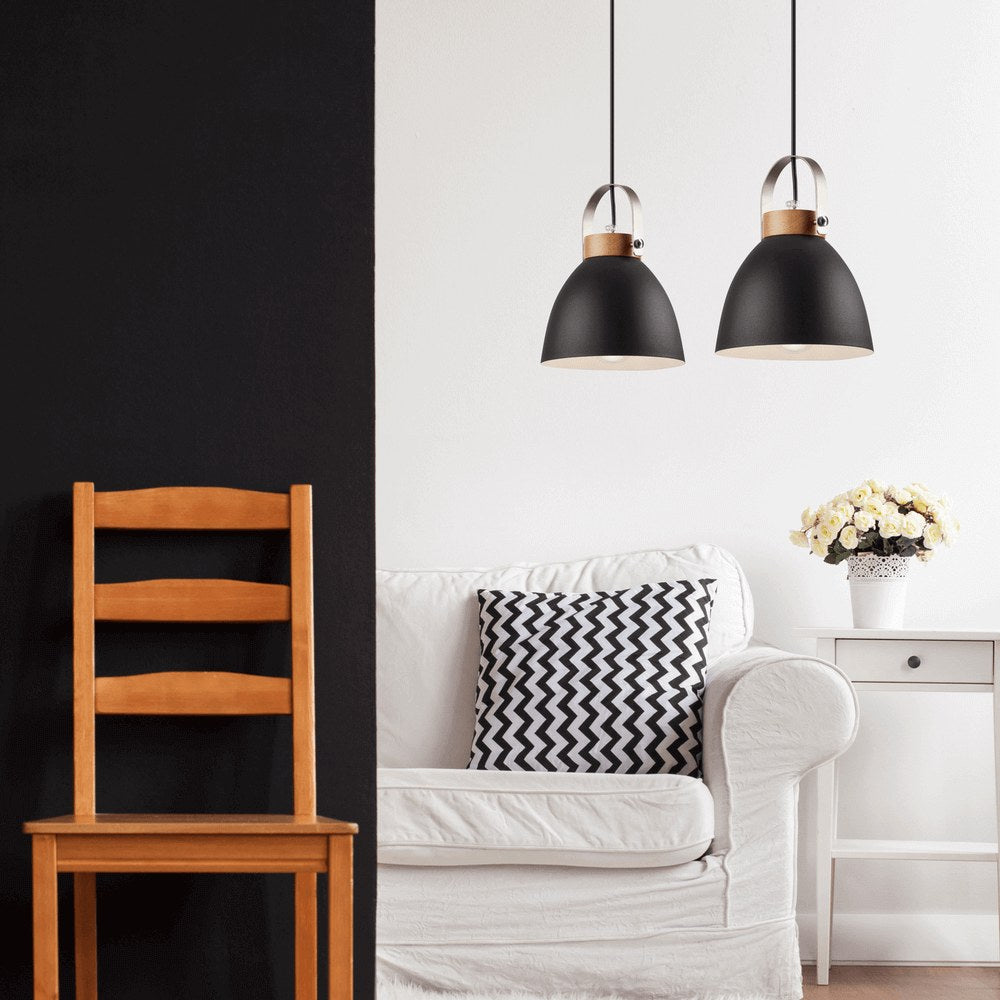 Scène intérieure avec deux suspensions noires devant un mur clair, canapé blanc et chaise en bois.