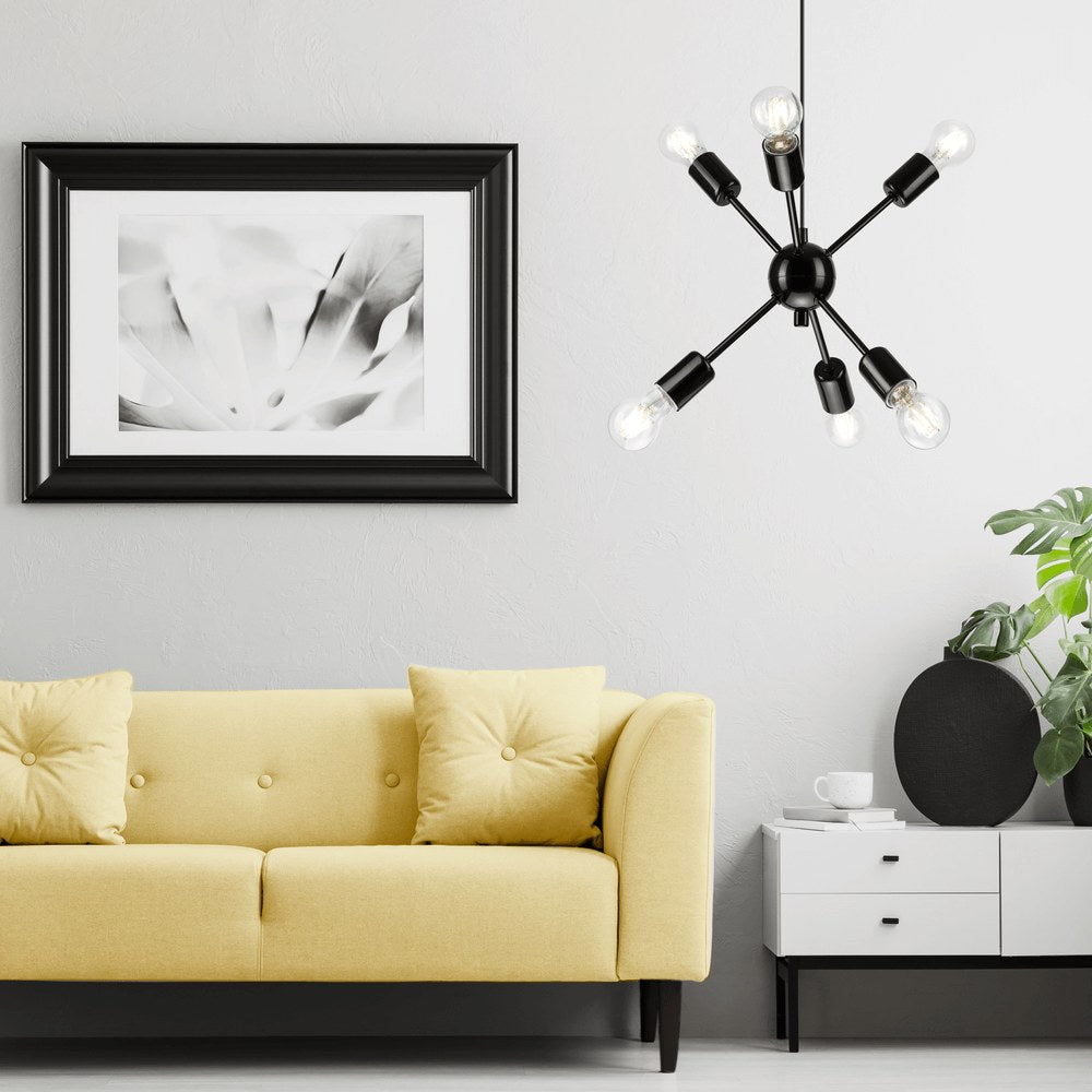 Mise en ambiance dans un salon avec canapé jaune, cadre mural noir et suspension noire allumée.