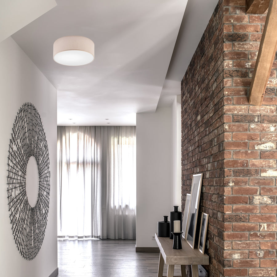 Plafonnier beige installé au plafond dans un couloir avec mur en briques