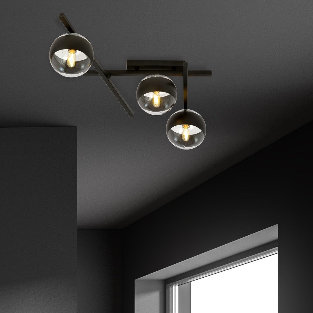 Mise en ambiance sur plafond sombre, trois globes diffusant une lumière chaude