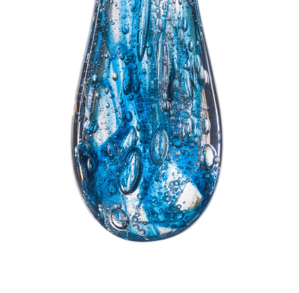 Goutte de verre bleu translucide photographiée de près sur fond blanc