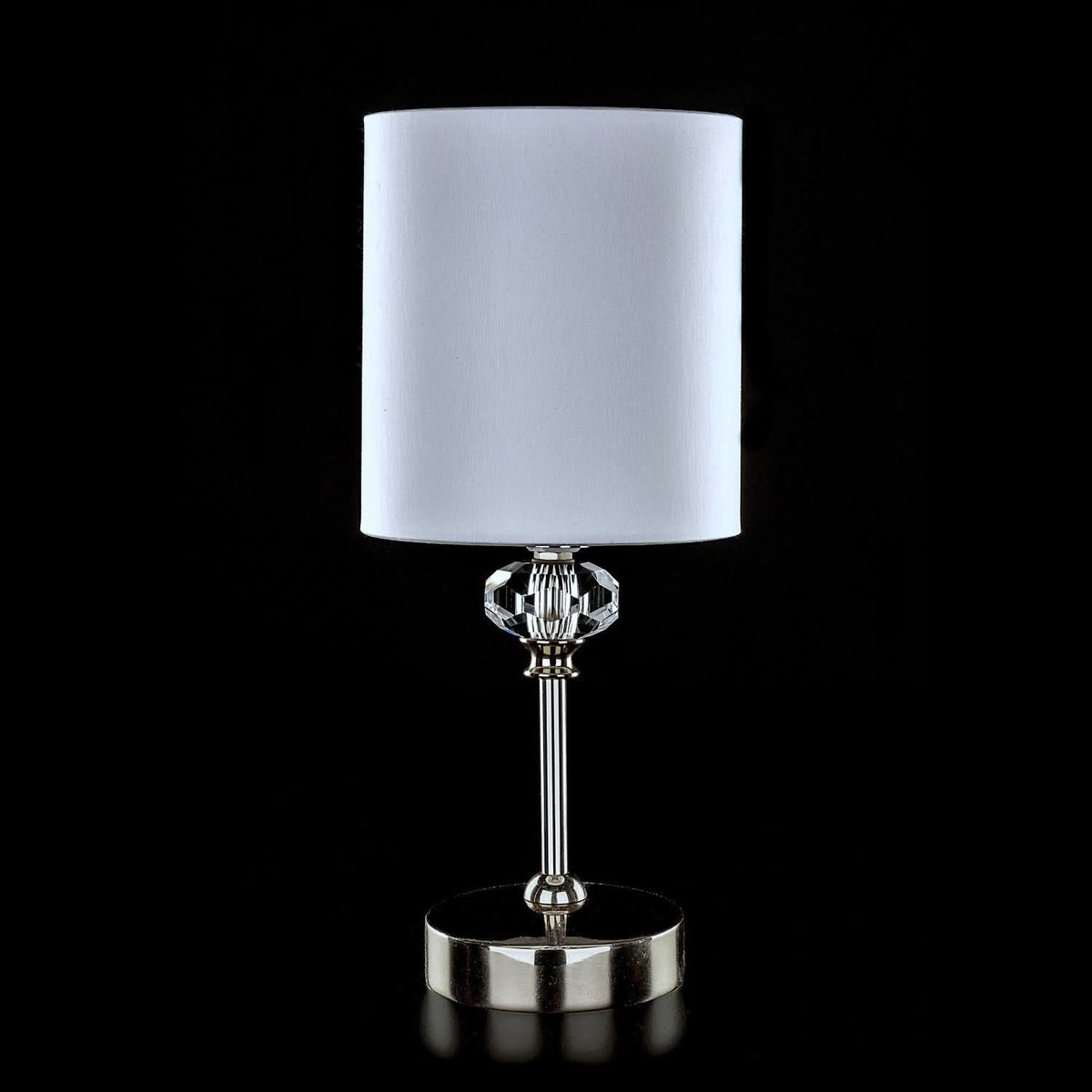 Version chromée du luminaire, pied métallique brillant et abat-jour blanc cylindrique.