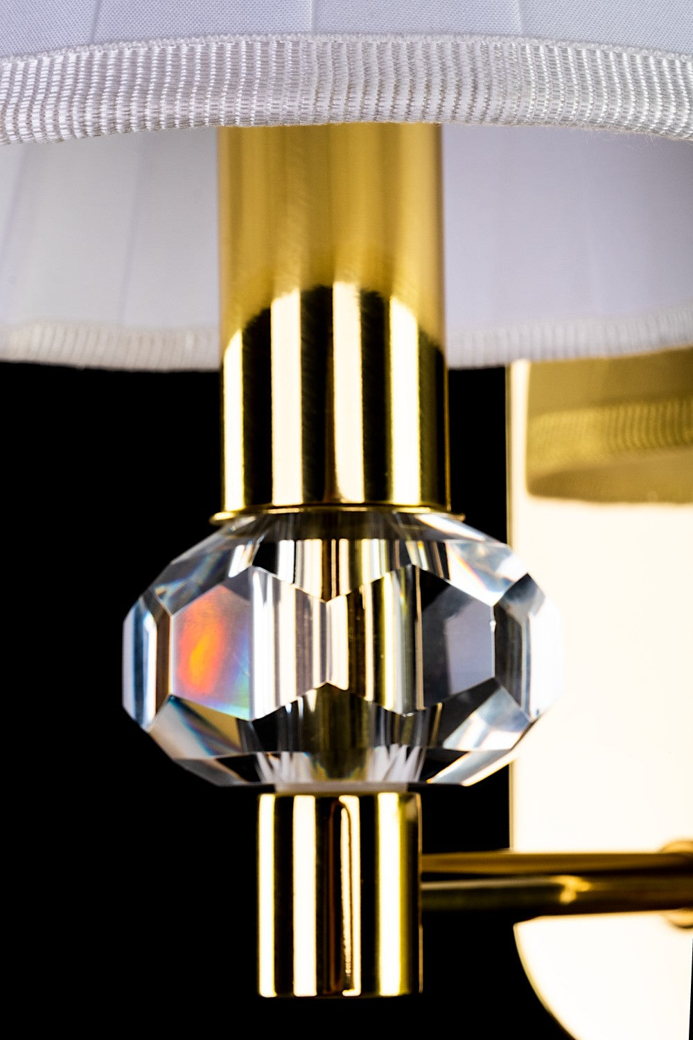 Détail du cristal facetté sur monture laiton doré, reflets irisés