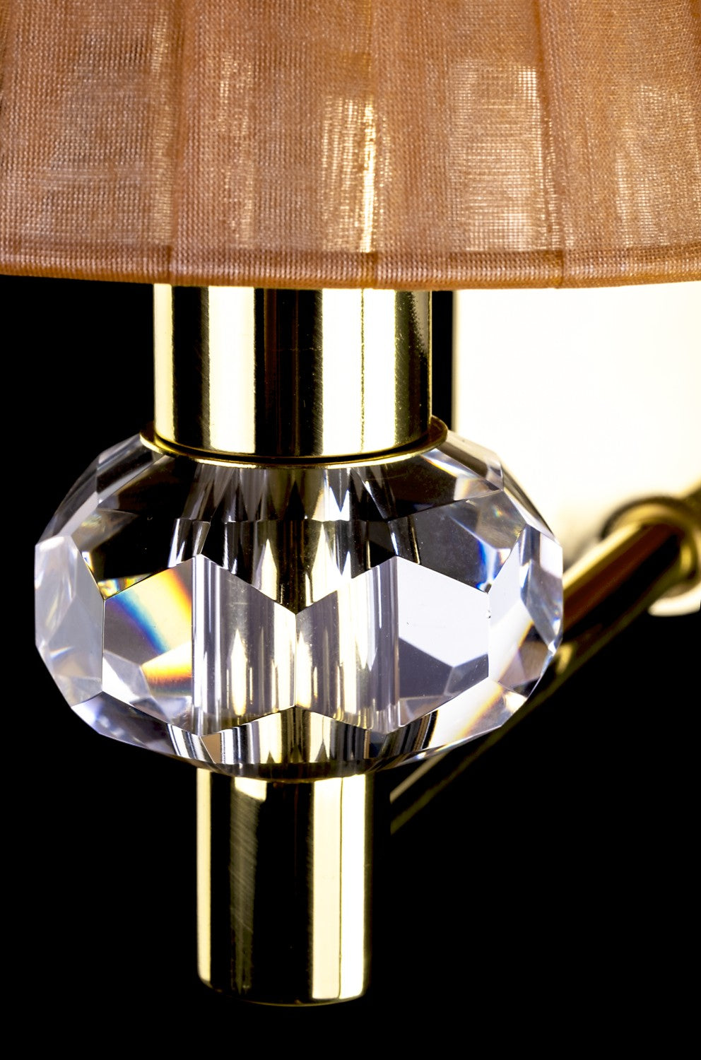 Détail du cristal taillé et du bras laiton poli sous l'abat-jour plissé