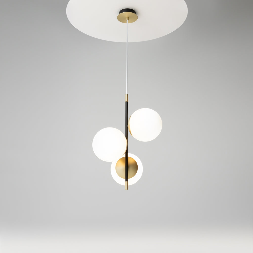 Luminaire allumé sous plafond, trois globes lumineux et structure noire dorée