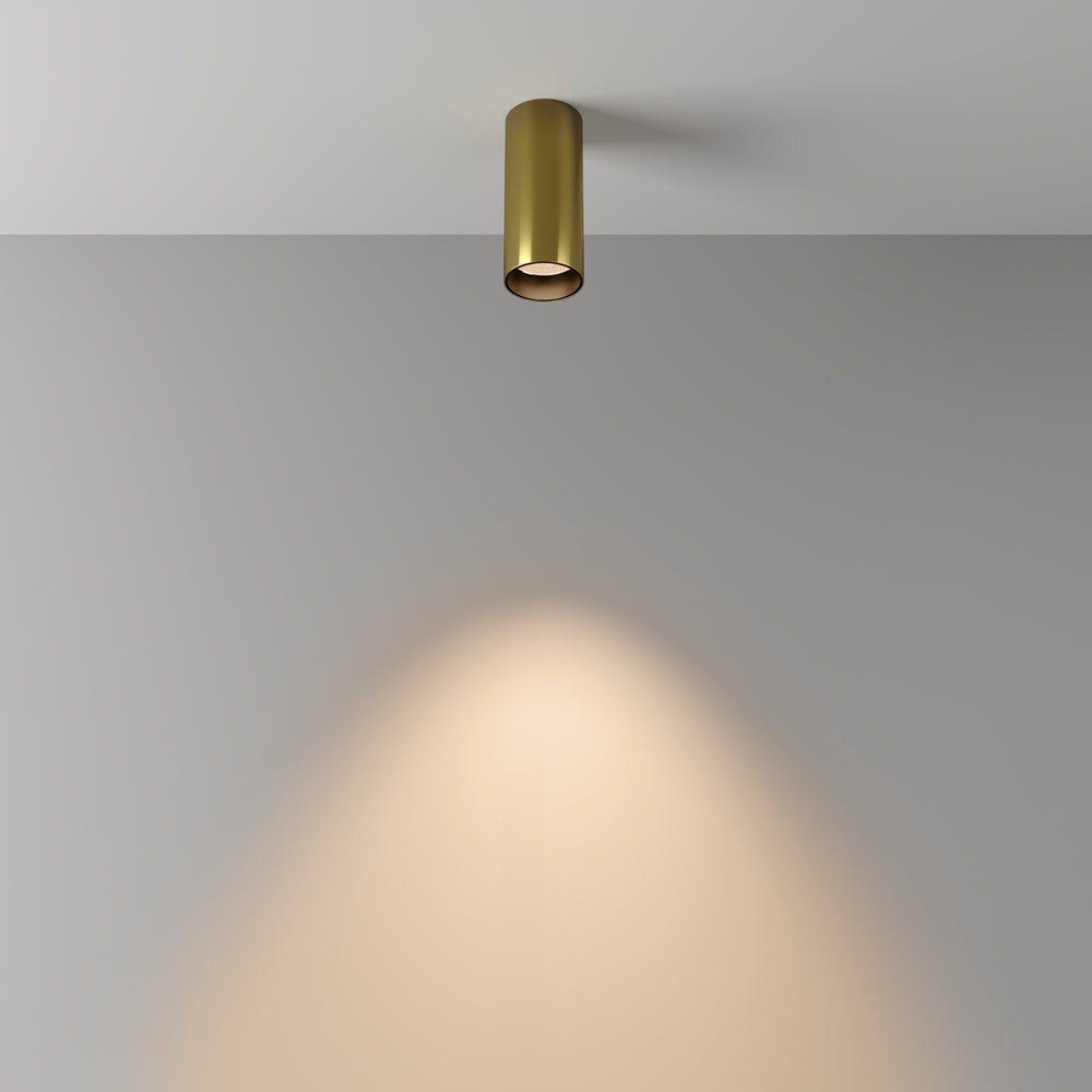 Mise en ambiance : cône de lumière chaude projeté sur un mur gris