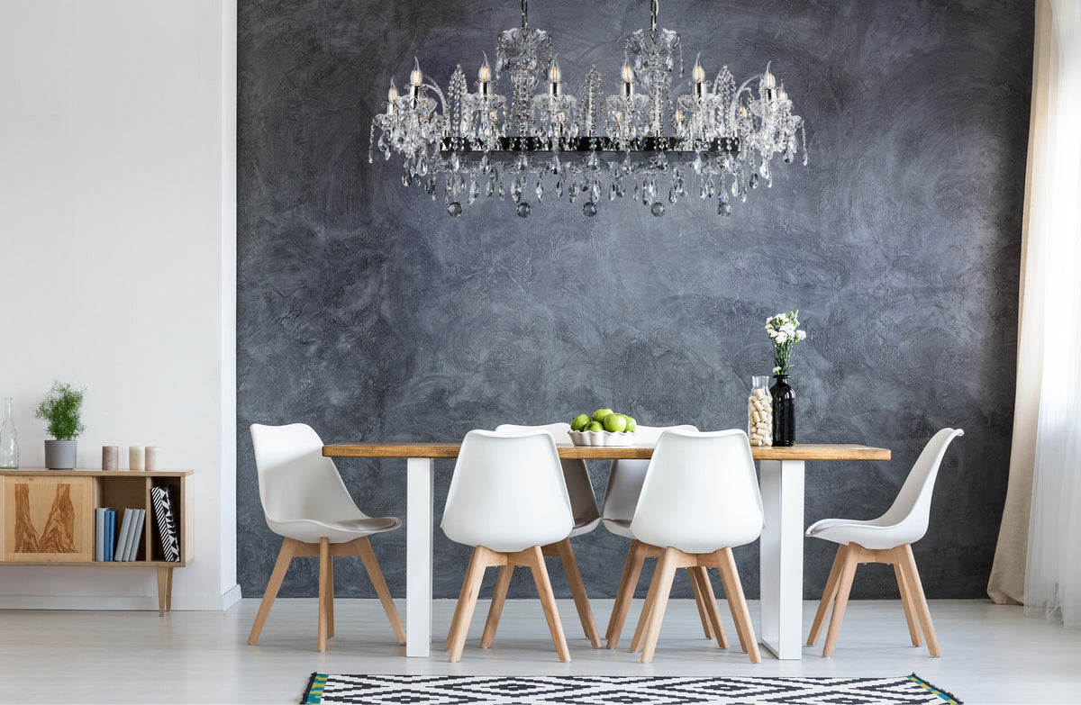 Mise en ambiance du lustre au-dessus d'une table blanche, mur gris texturé en fond.