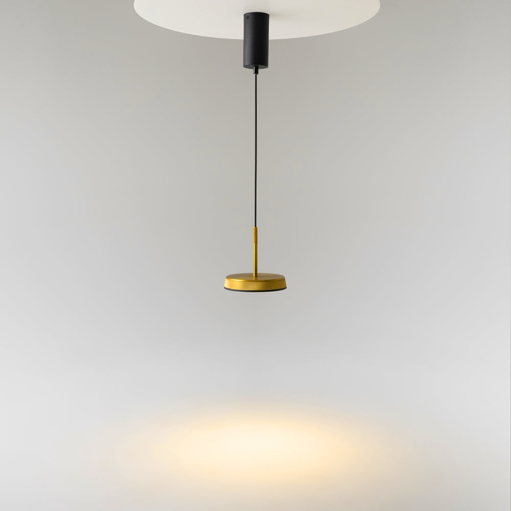 Luminaire suspendu au plafond, diffusant une lumière chaude et tamisée dans la pièce
