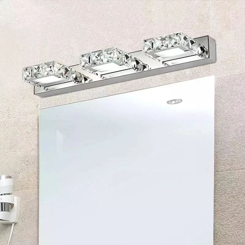 Vue rapprochée du luminaire éclairé au-dessus d'un miroir, carrelage beige en fond