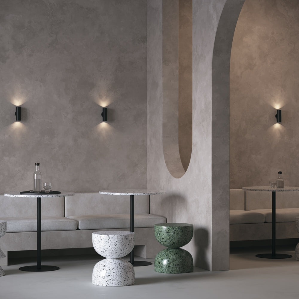 Mise en ambiance dans un intérieur béton avec deux appliques noires éclairant vers le haut et le bas