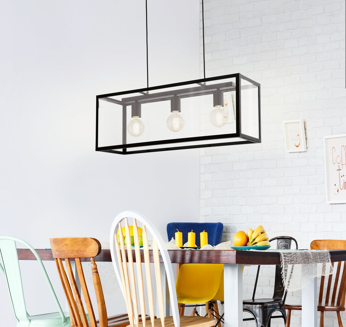 Vue en légère plongée du luminaire au-dessus d'une table aux chaises colorées