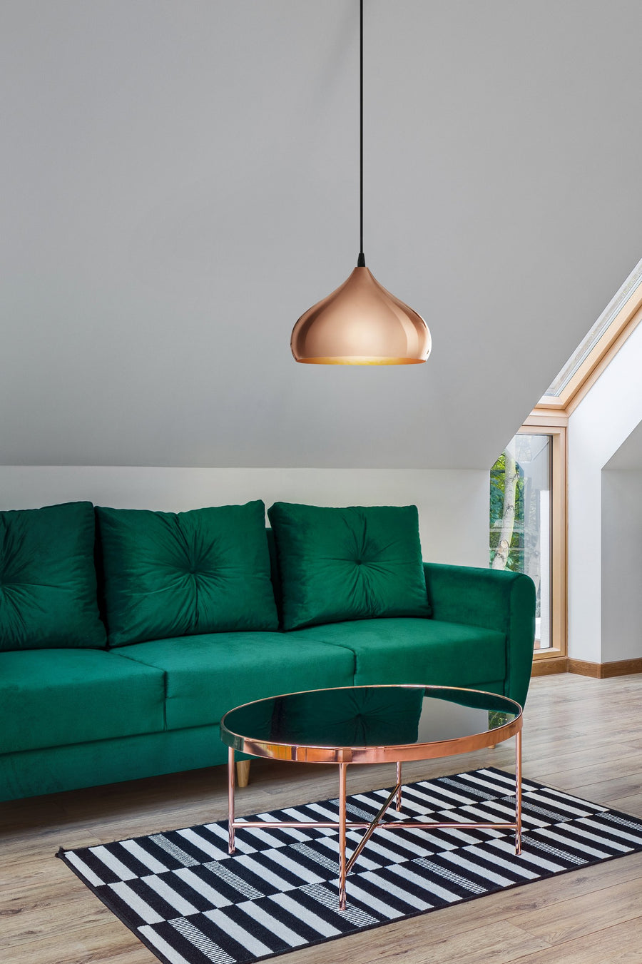 Luminaire suspendu éclairé au-dessus d'un canapé vert émeraude contemporain