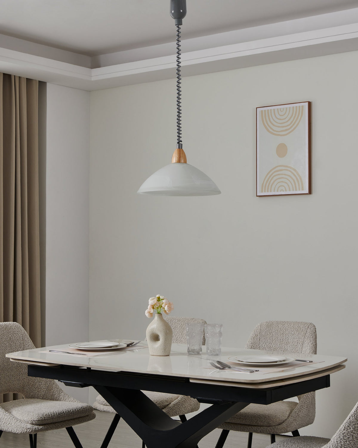 Luminaire suspendu éclairant une table à manger dans un intérieur contemporain aux tons neutres
