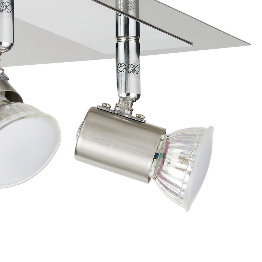 Détail en gros plan d'une tête orientable et de sa rotule en nickel satiné avec ampoule.