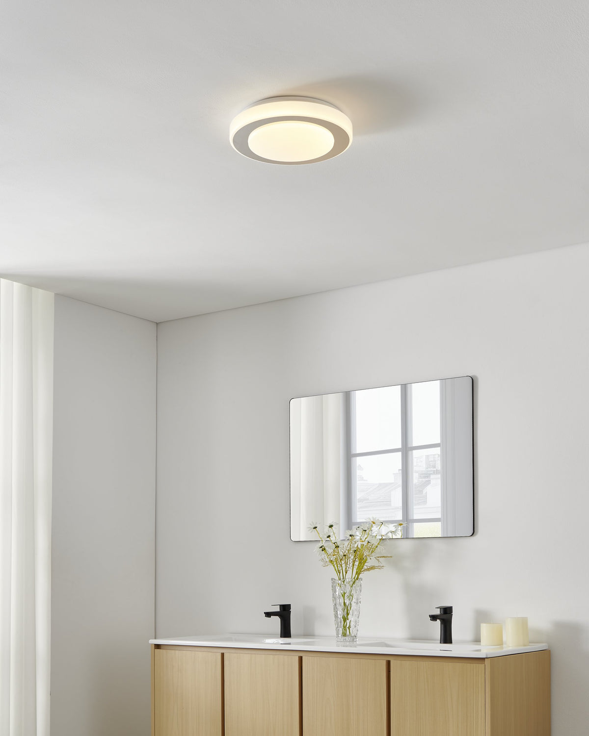 Mise en ambiance salle de bain, plafonnier allumé au-dessus d'un meuble vasque en bois