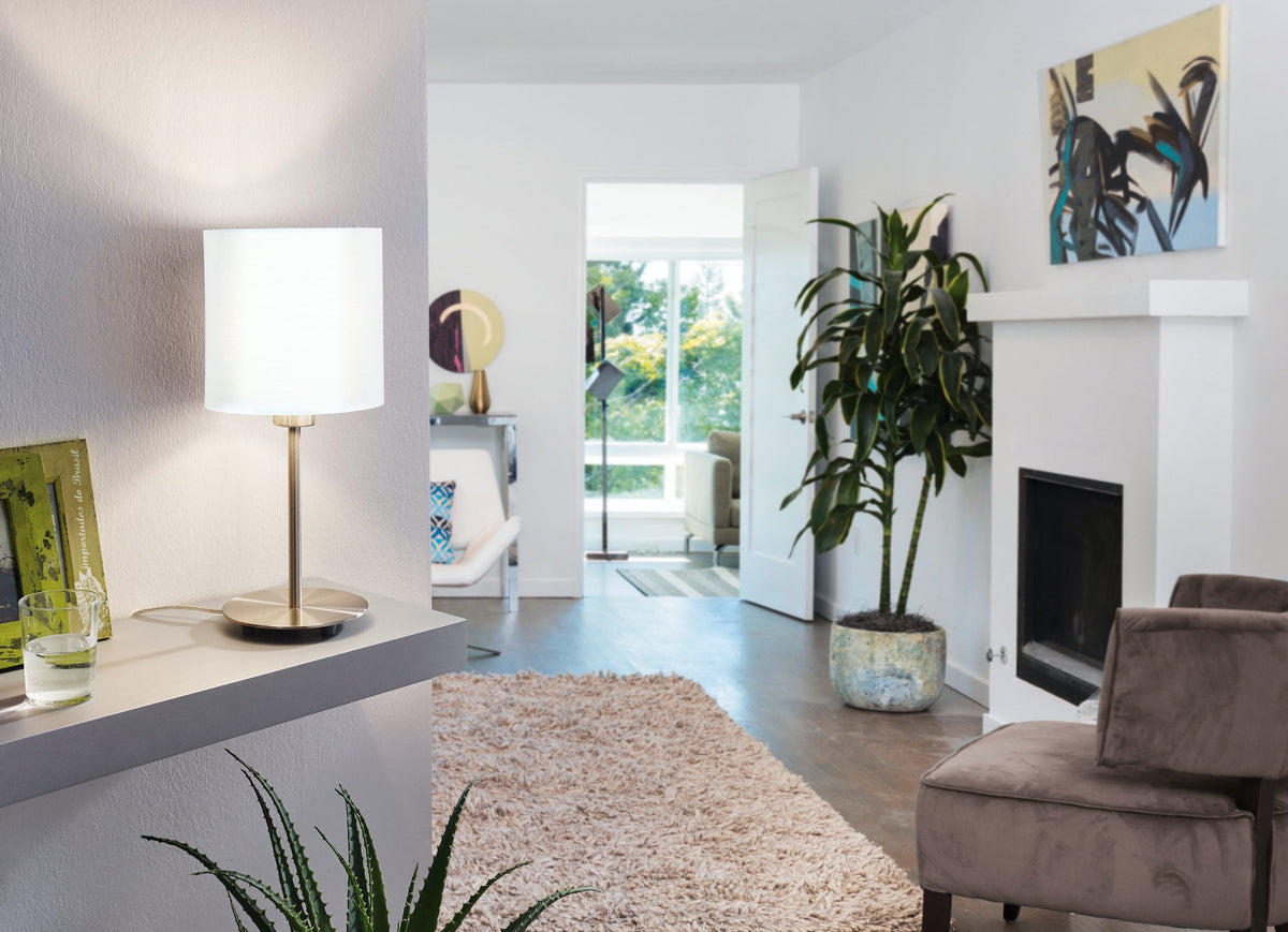 Mise en ambiance : lampe allumée posée sur un meuble dans un salon clair.