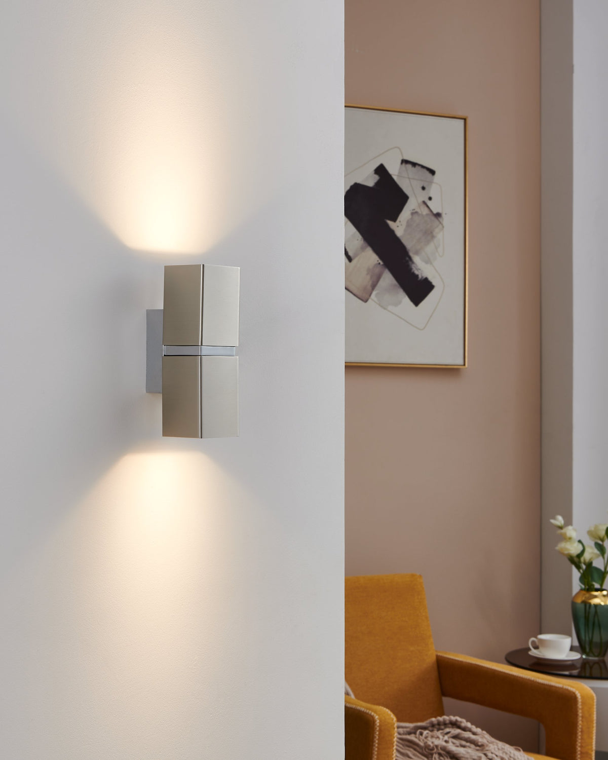 Applique allumée diffusant une lumière haut et bas sur un mur clair