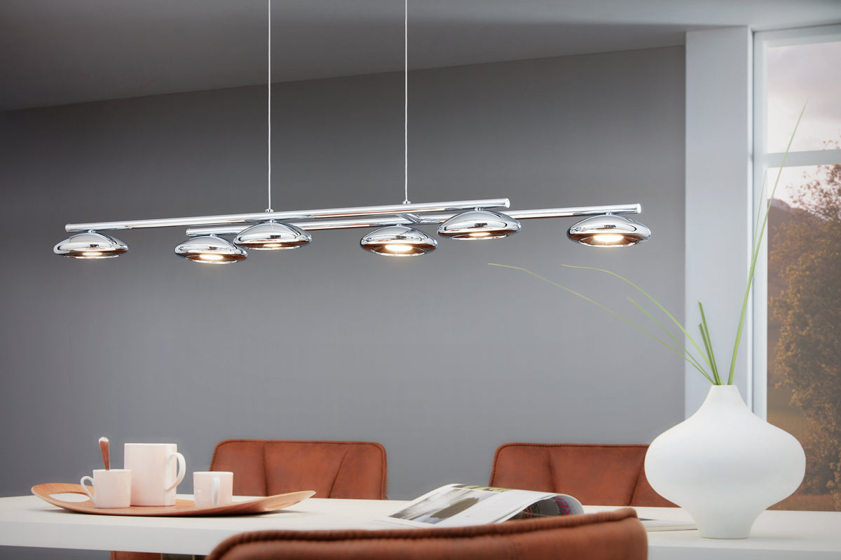 Mise en ambiance au-dessus d'une table à manger, abat-jours chromés allumés dans un intérieur gris