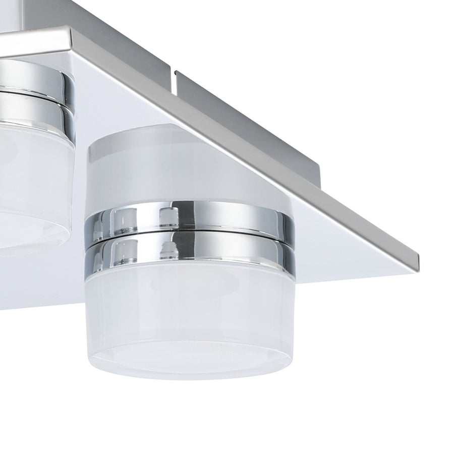 Gros plan sur un diffuseur cylindrique en verre opalin et sa bague chromée brillante.