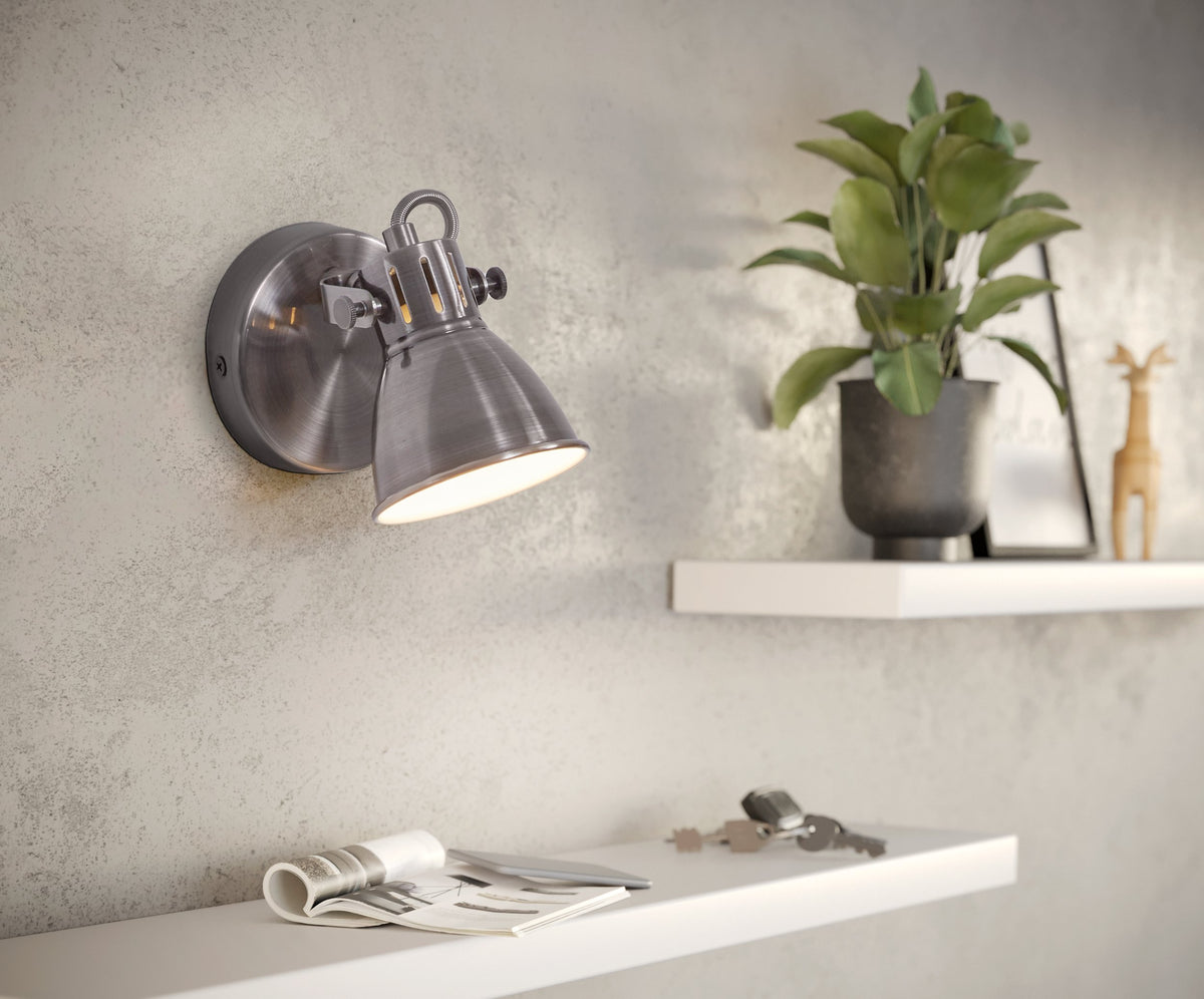 Ambiance salon, spot allumé sur mur gris, étagère blanche et plante verte