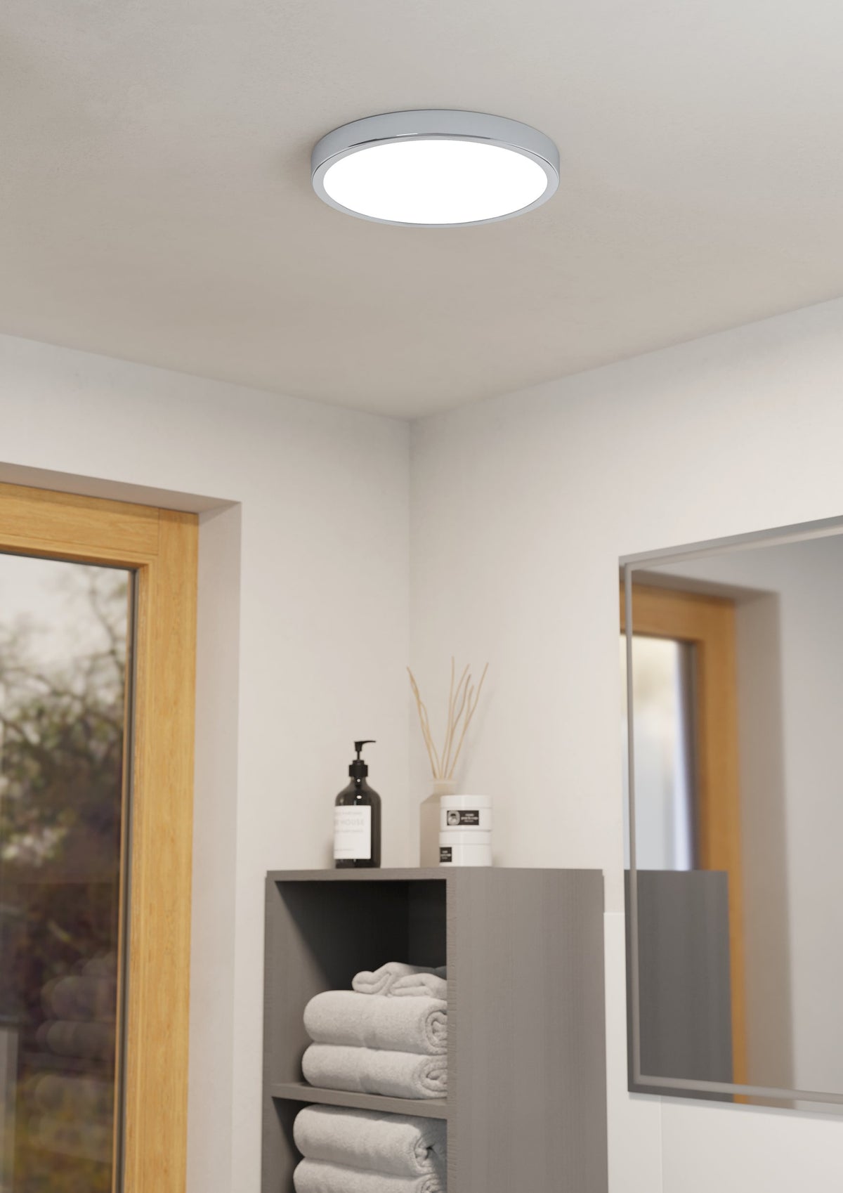 Mise en ambiance du plafonnier blanc et chromé au plafond d'une salle d'eau.