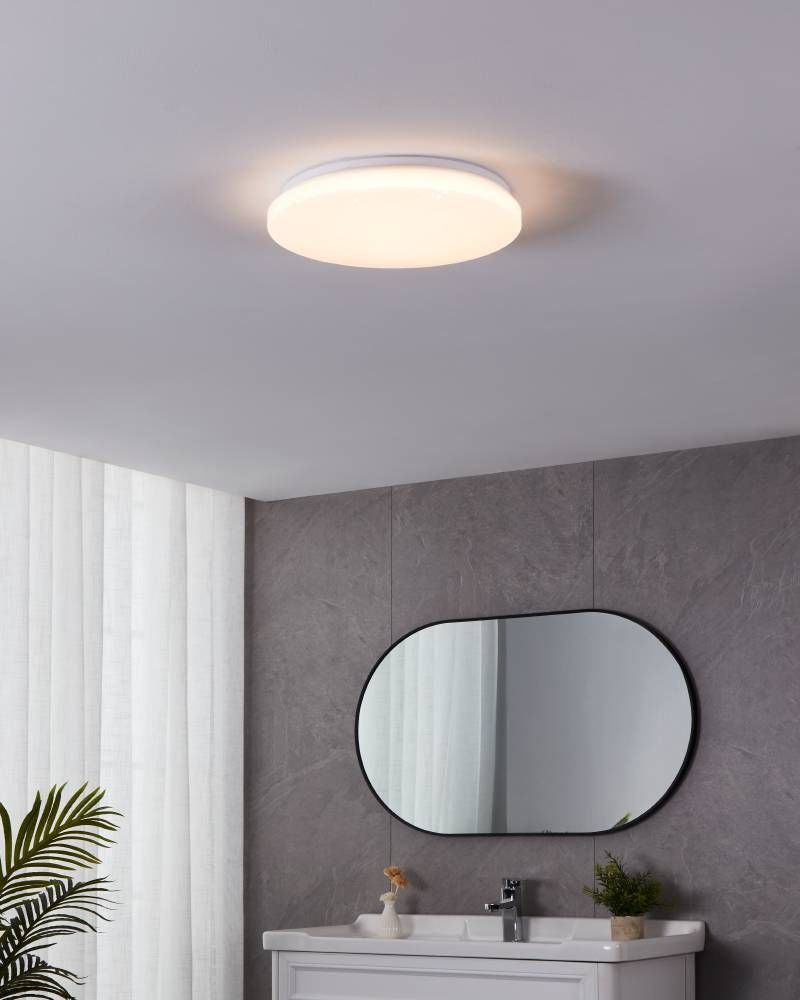 Mise en ambiance au-dessus d'un miroir ovale dans une salle de bain grise