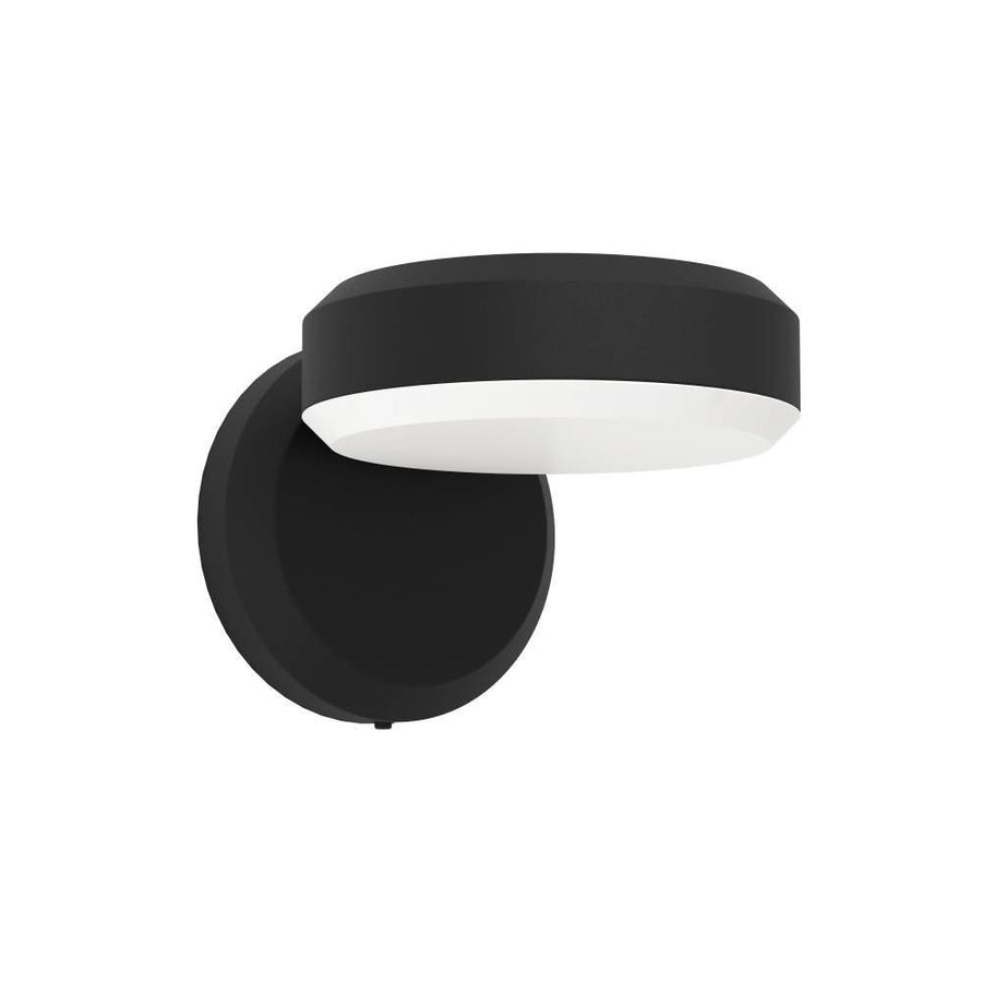 Vue de trois-quarts d'une applique murale noire, base ronde et diffuseur blanc.