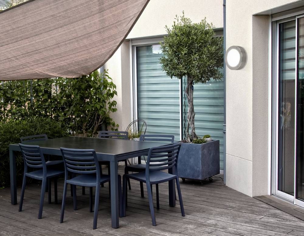 Mise en ambiance de l'applique murale allumée sur un mur de terrasse en bois
