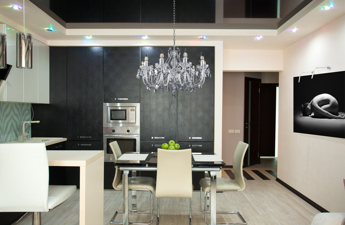 Lustre en cristal installé au-dessus d'une table dans une cuisine moderne aux meubles noirs