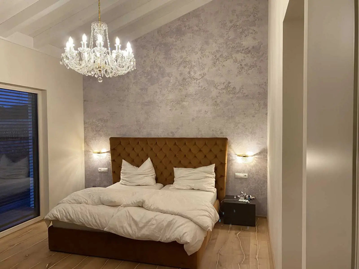 Mise en ambiance dans une chambre, lustre allumé suspendu au plafond à poutres