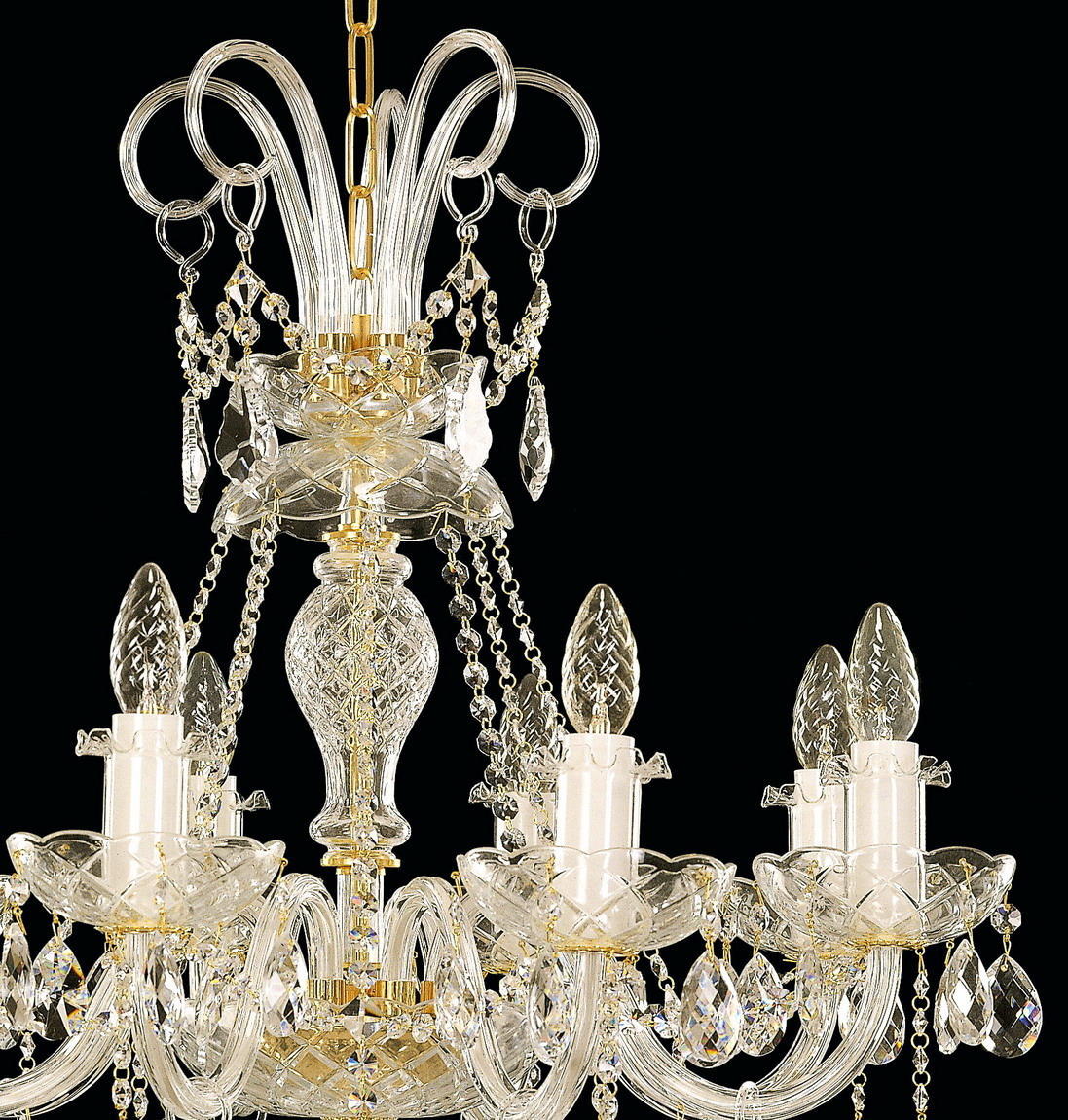Gros plan du sommet du lustre : chaîne dorée, tiges de cristal recourbées et pendeloques.