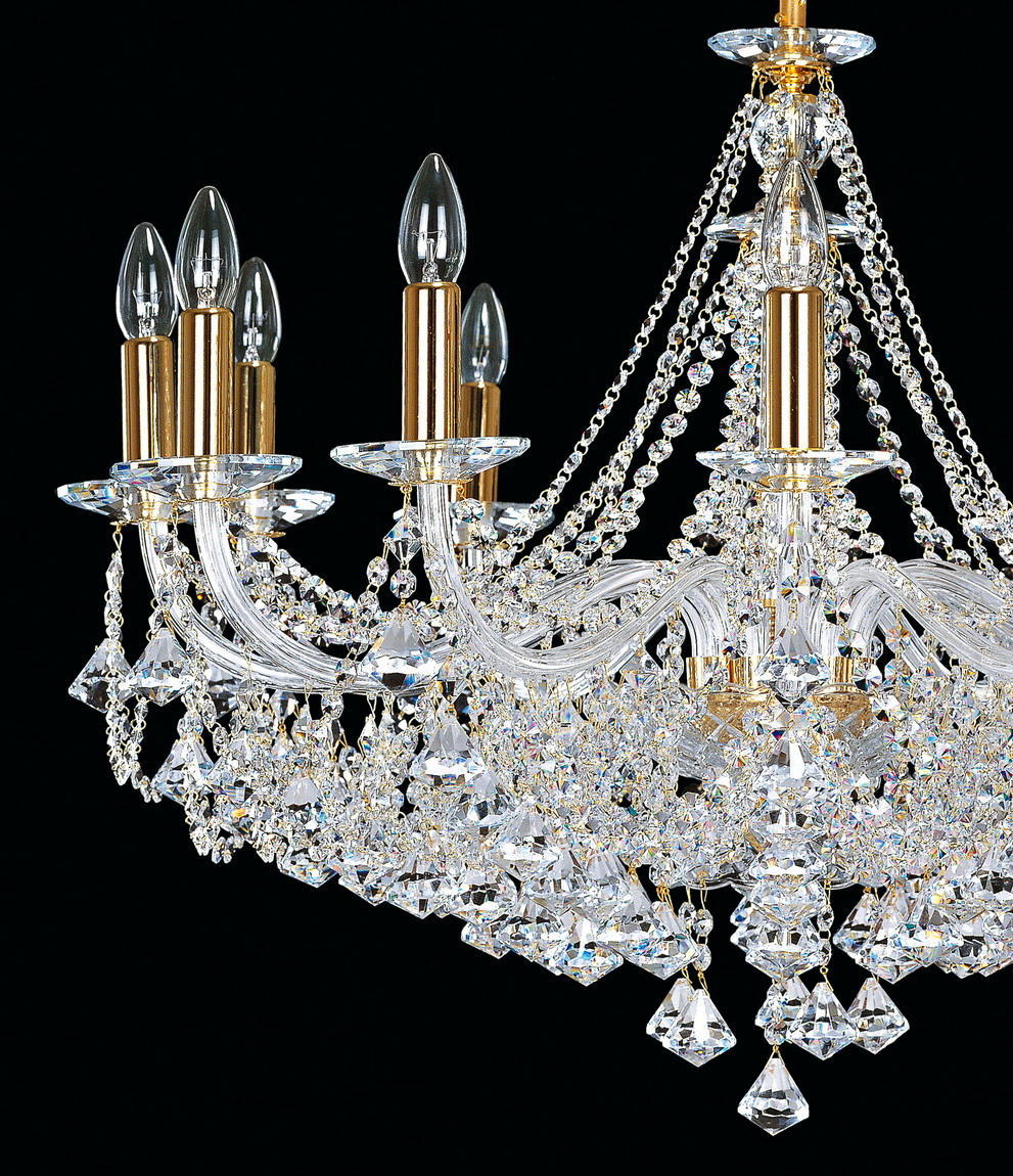 Vue rapprochée en contre-plongée du lustre, détaillant les bras dorés et les pendeloques en cristal.